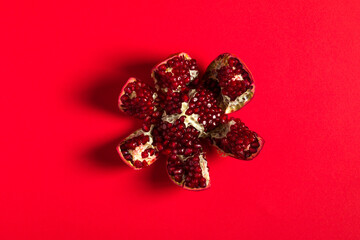 Peeled pomegranate on a red background.