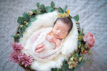 ニューボーンフォト_おくるみに包まれてかごの中で幸せそうにすやすや眠る生まれたての赤ちゃん