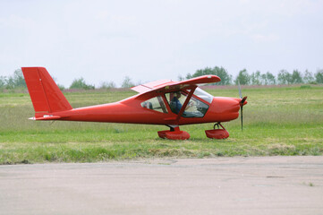Fototapeta na wymiar Light sport plane landed on the landing field, silhouette of a pilot sitting in a cockpit