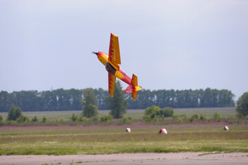 Radio controlled plane flying in the sky performing aerobatics - obrazy, fototapety, plakaty
