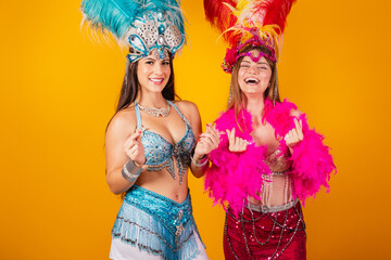 two brazilian female friends with queen clothes from samba school, carnival. Feather crown. heart...