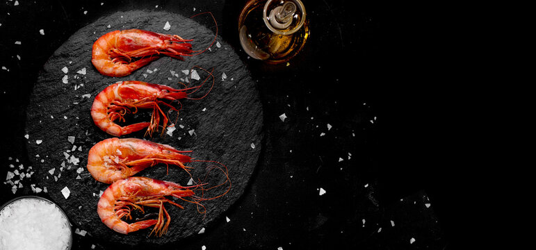 Prawns cooked with salt and oil on a stone plate on banner format