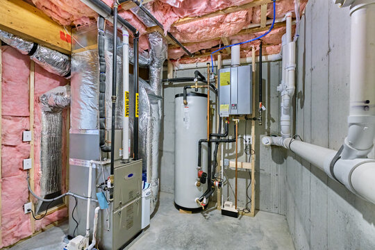 Unfinished basement mechanical room with condensing tankless water heater, storage tank, plumbing and heating systems
