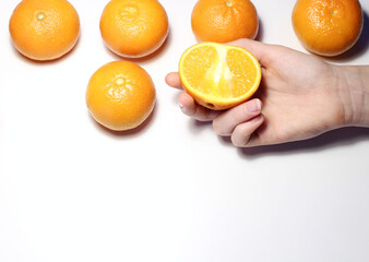 Oranges isolated on white background. Woman's hand holding a half fresh orange Homemade lemonade from oranges.Food background, healthy food.Blurred background.