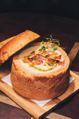 Delicious cream soup with bacon in bread