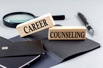 CAREER COUNSELING text on wooden block on black notebook , business concept