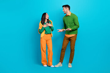 Full length photo of two friends male female dating weekend speaking loudly isolated on blue color...