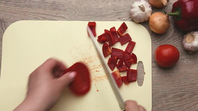 Fresh red pepper finely chopped into pieces on a kitchen board