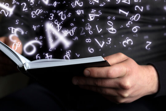 numerology, a man holds an open book in his hands, surrounded by numbers