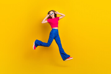 Photo of cheerful cute lovely lady wear trendy outfit running empty space party weekend summer holiday isolated on yellow color background