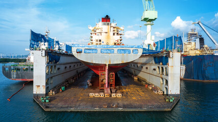 cargo container ship at dry dock concept maintenance service working in the sea. Insurance and...