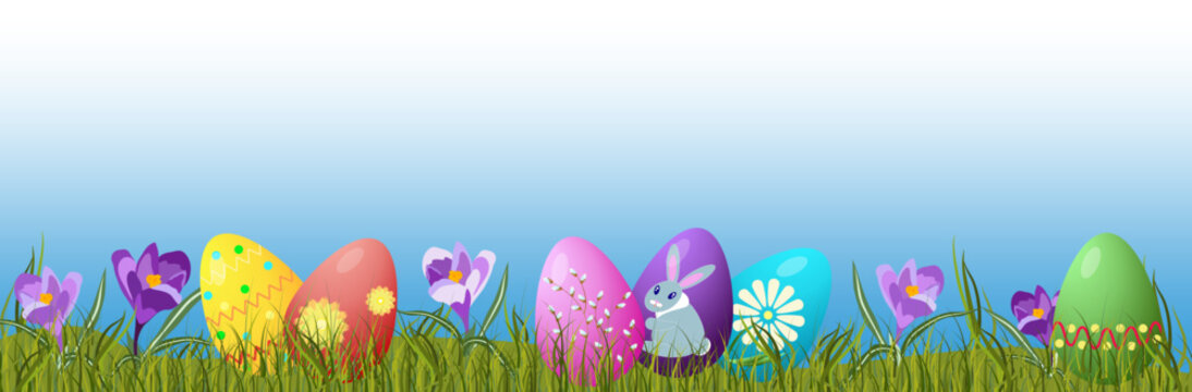 Easter background, banner with painted eggs among grass and crocuses on the lawn on a translucent sky background with copy space