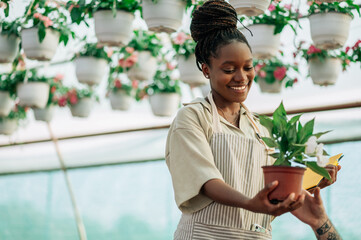African american woman working in a greenhouse flower plant nursery