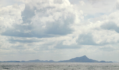 Panorama of islands with a tall mountain under heavy cloudscape