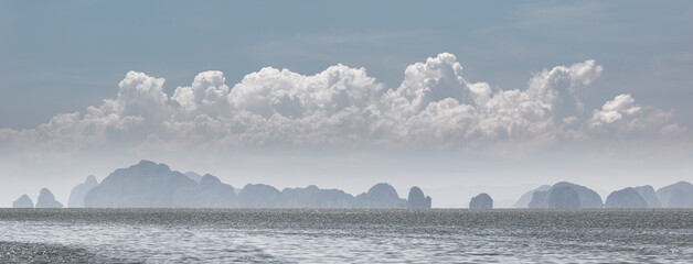 Panorama of cliff islands landscape and huge cloudscape above. Thailand landscape.