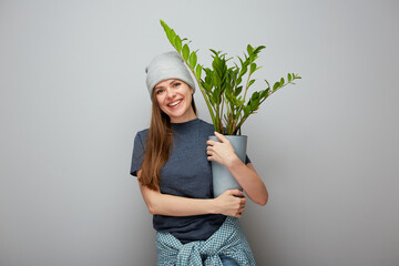 Woman with home plant zamioculcas in pot. Smiling girl portrait with copy space.
