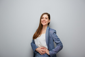 Smiling business woman in blue suit. Female portrait near gray wall. - 565398540