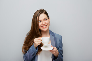 Business woman wearing suit drinking coffee looking at side.
