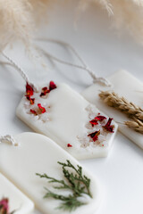 Fototapeta na wymiar Aroma sachet with dried flowers with coconut or organic soy wax. Close up on white background