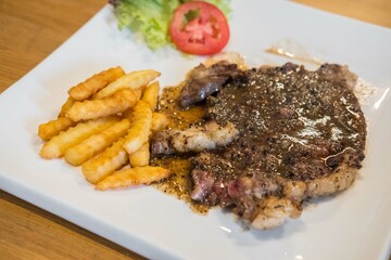 Medium rare meat on plate with sauce and fries