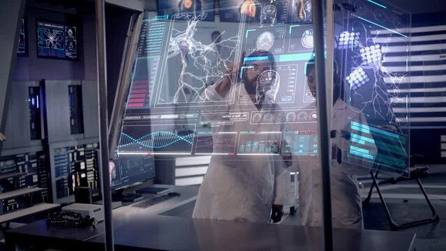 Scientists analyze Brain Scan Data and Neural Network Activity on Futuristic Transparent Touchscreen. Patient lying on chair as doctors study behind a glass room. Shot on RED Epic W Helium 8K Camera.