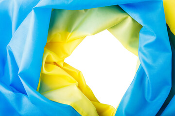 Fabric curved flag of Ukraine. yellow and blue Hole in the ukraine flag with torn sides.
