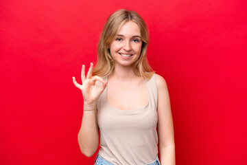 Young English woman isolated on red background showing ok sign with fingers