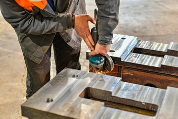 Grinding burrs and metal with an angle grinder with sparks.