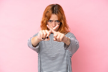 Young caucasian woman isolated on pink background making stop gesture with her hand to stop an act