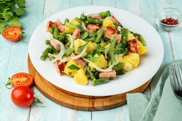 Belgian potato salad with green beans, a traditional dish in a white plate.