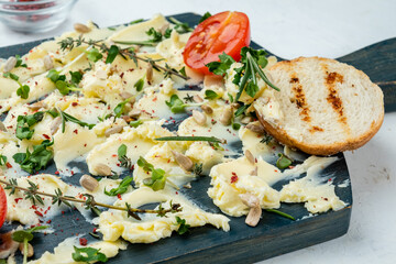 Trendy butter snack with various herbs, close-up. Board with butter close-up.