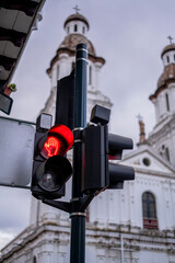 traffic lights in a tourist city with a church in the background in red and green