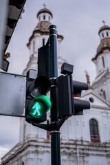 traffic lights in a tourist city with a church in the background in red and green