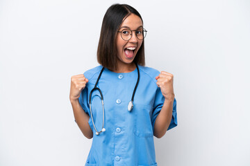 Young surgeon doctor woman isolated on white background celebrating a victory in winner position