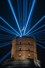Vilnius Light Festival. Gediminas tower or castle with Lithuanian flag in winter with snow and...