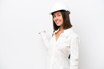 Young architect woman with helmet and holding blueprints isolated on white background extending hands to the side for inviting to come