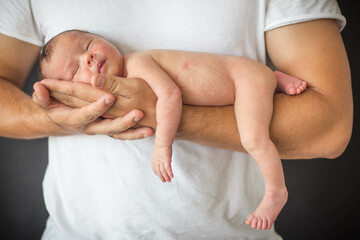Fototapeta na wymiar newborn baby in father's arms, parental care for new life