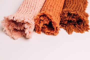 Background for design. Waffle fabrics in orange, brown and pink with fringes
