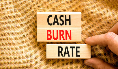 Cash burn rate symbol. Concept words Cash burn rate on wooden blocks on a beautiful canvas table canvas background. Businessman hand. Business cash burn rate concept. Copy space.