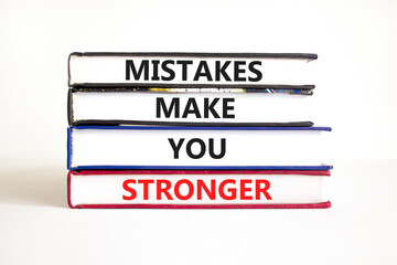 Mistake make stronger symbol. Concept words Mistakes make you stronger on books. Beautiful white table white background. Business mistake make stronger concept. Copy space.