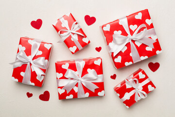 Gift boxes with hearts on concrete background, top view