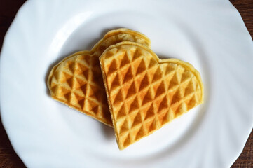 Heart shaped waffles on the plate. Valentines Day breakfast. Flat lay love concept.
