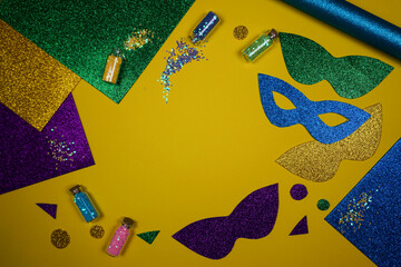Making paper masks for the Mardi Gras carnival. On the yellow table are laid out items for the celebration of carnival. Mockup.