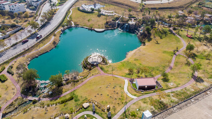 Aerial view of a park with an artificial lake with the city in the background