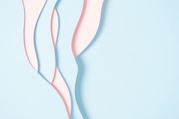 Abstract colored paper texture background. Minimal paper cut composition with layers of geometric shapes and lines in pastel pink and light blue colors. Top view, copy space