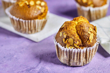 Vanilla Caramel Nuts Muffins In Paper Cups On purple background