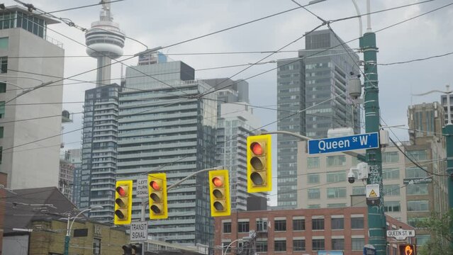 queen street toronto with cn tower and cityscape behind in slow motion
