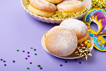 Mardi Gras King Cake Doughnuts or Donuts, Carnival Masks on Purple Background.