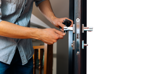 man repairing the doorknob. closeup of worker's hands installing new door locker