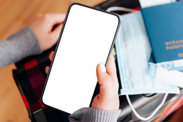 The woman holding the mobile phone a mockup for digital vaccination certificate in one hand and passport, mask and ticket in another one